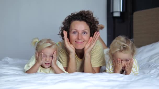 Mom Her Playful Children Lying Bed Stomachs Hiding Palms Covering — Stock Video
