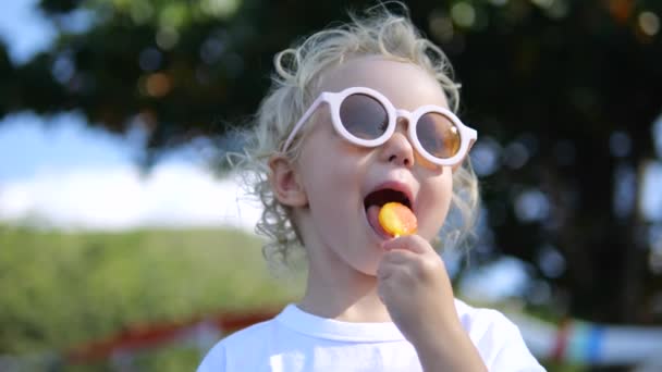 Low Angle Shot Caucasian Child Cool Fashionable Sunglasses Licks Sugary — Stock Video