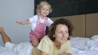 Kollarını açmış, annelerin sırtında oturan küçük kız gökyüzünde uçtuğunu hayal ediyor. Kızı annesinin boynuna sarılıyor. Sevgi, anne ve çocuk arasındaki sevgi..