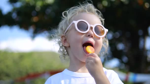 Nízký Úhel Záběr Kavkazské Dítě Chladných Módních Slunečních Brýlích Olizuje — Stock video