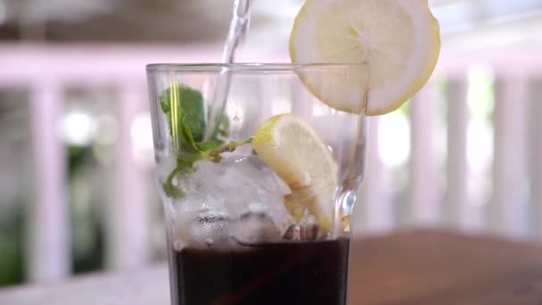 Close Gieten Sprankelend Water Siroop Glas Met Schijfjes Citroen Ijsblokjes — Stockvideo