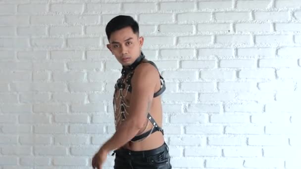 漂亮的亚洲男人在一个时髦的俱乐部里跳舞同性恋 男人穿着皮衣从皮带和锁链的家伙寻找一对夫妇的爱情 世界上的Lgbt社群 男女同性恋 双性恋和变性者Bdsm服装 — 图库视频影像