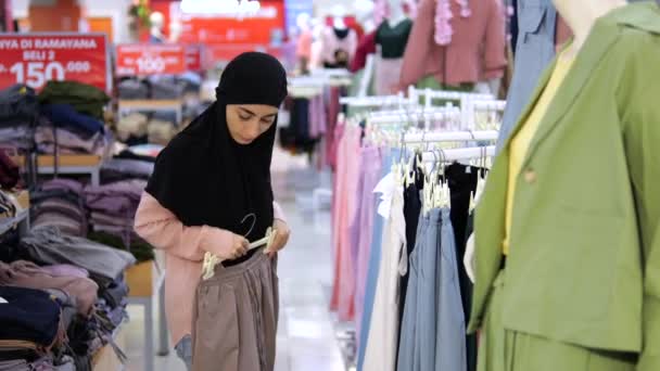 Арабская Женщина Хиджабе Выбирает Брюки Брюки Бутике Мусульманский Клиент Сравнивает — стоковое видео