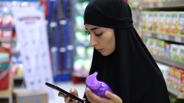 Zbliżenie Pięknej Młodej Kobiety Hidżabie Środku Półek Sklepowych Telefonem Komórkowym — Wideo stockowe