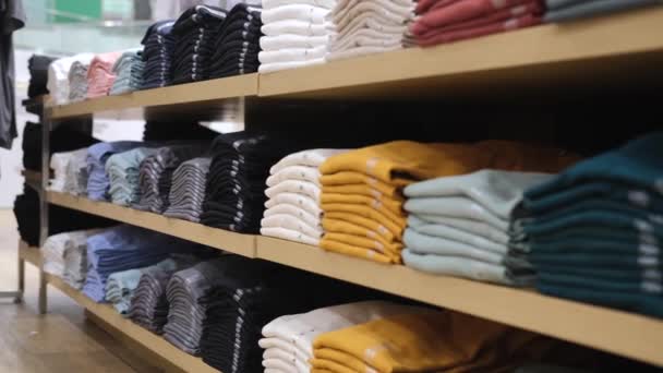 男性と女性のための服の多種多様な棚 ブティックの服は 利便性のために色やパターンによってきれいに配置され 衣料品店に顧客を引き付けるために — ストック動画