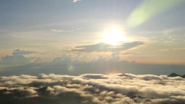 山の高い雲を照らす朝の日のシネマティックショット 日の出の雲の広いショット 山の風景で日の出の雲の美しさと威厳を示しています 雲の上の日の出をお楽しみください — ストック動画