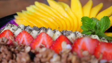 Muzlu, mangolu, tahıllı, çilekli renkli smoothie kasesi. Lezzetli smoothie kasesi sağlıklı yemek için mükemmel yemek. Kavram nefis bir meyve suyu kasesi, nefis ve besleyici..