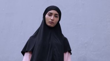 Beautiful angry muslim woman hijab showing middle finger doing fuck you. Angry expression, provocation and rude attitude. In movement one read emotional anger, which to flare up background of beliefs