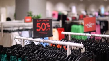 Pantalonlu Kara Cuma tabelası, giyim mağazasında yüzde 50 indirim. Modern mağazadaki pantolon standında Kara Cuma indirimi. Kara Cuma 'da indirimli pantolon al.