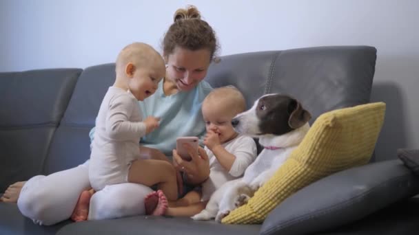 Ευτυχισμένη Μητέρα Δίδυμα Και Σκύλο Βλέποντας Κινούμενα Σχέδια Στο Smartphone — Αρχείο Βίντεο