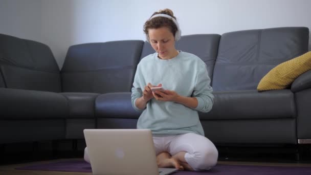 Lady Sentado Posição Lótus Usa Vários Dispositivos Mesmo Tempo Fones — Vídeo de Stock
