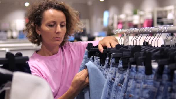 Junge Frau Auf Der Suche Nach Jeans Bekleidungsgeschäft Black Friday — Stockvideo