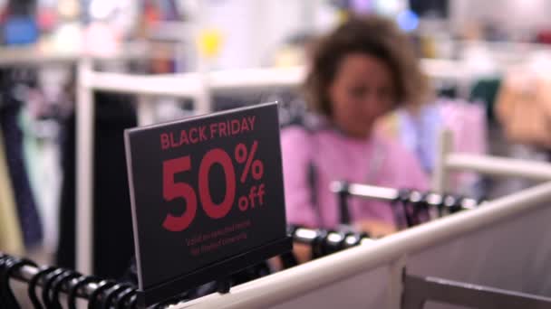 Giysi Mağazasındaki Kara Cuma Tabelasını Değiştiren Kıyafet Arayan Bir Kadın — Stok video