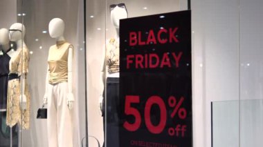 Modern giysiler Kara Cuma 'da% 50 indirimli. Kadın giyim mağazasının reklam pankartına yakın çekim. Kıyafetlerde yüzde 50 indirim var. Alışveriş konsepti% 50 indirimli kıyafet alır.