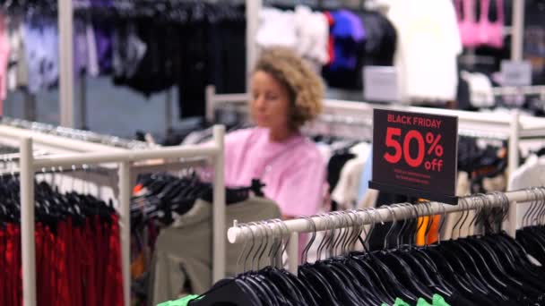 Giysi Mağazasında Kara Cuma Tabelası Arka Planda Kıyafet Seçen Müşteriler — Stok video