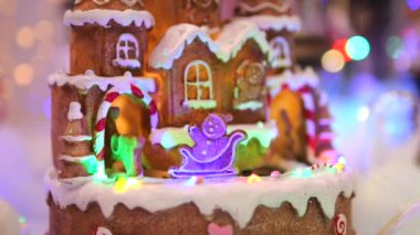 Çatıda beyaz kremalı güzel zencefilli kurabiye evi ve atlı karınca ve zencefilli kızakla gezen zencefilli ekmek insanları. Noel kutlamaları için lezzetli zencefilli kurabiyelerin olduğu sinematik video.