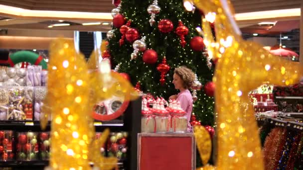 Kvinna Letar Efter Julklapp Köpcentret Mot Bakgrund Festlig Julgran Selektivt — Stockvideo