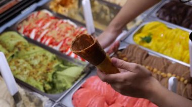 Satıcı tatlı kaşığı dondurmayı tepsiden çıtır külahlara koyar. Dondurma çeşitliliği çeşitliliğinde inanılmazdır. Dondurma yetişkinlerin ve çocukların en sevdiği tatlıdır..