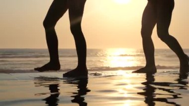 Küçük çocuk ayakları gün batımında okyanus kıyısında mutlu bir şekilde su sıçratır. Kaygısız çocukluk mutluluğu anları okyanusun güzelliğiyle başbaşa. Aileyle küçük mutlu anların önemi kavramı