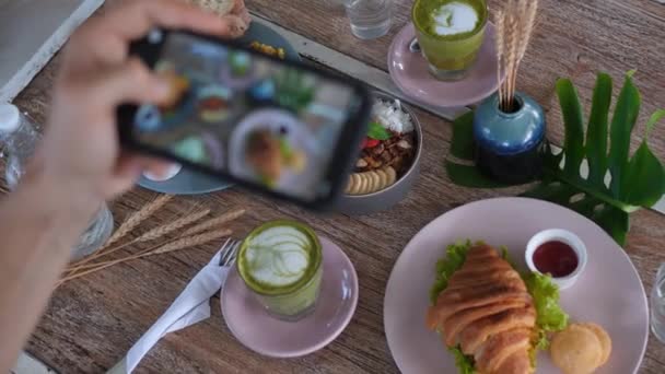 顶级美食博主在咖啡店为早餐拍照 女性的手在手机上为社交网络拍摄时尚时尚风格的食物图片 与朋友共进早餐 享用健康美味的食物 — 图库视频影像