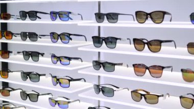 Teknolojik güneş gözlüğü modelleri olan bir optik mağaza. Gözleri parlamadan koruyan polarize optik mercekli gözlükler. Alıcılar göz rahatlığı ve güvenlik için optik performansı olan gözlükleri seçiyorlar.