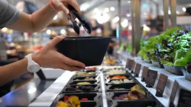 Vejetaryen kadın sağlıklı beslenme noktasında akşam yemeği hazırlıyor çünkü salata çeşitli taze sebzeler seçiyor vejetaryenler dengeli beslenme için yiyecek seçimlerine özellikle dikkat ediyorlar.