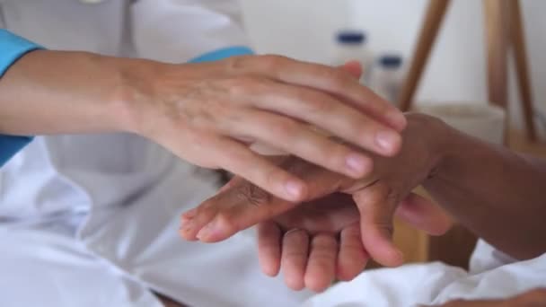 医生的手捂住了病人疼痛的手 医生手小心地捂住老年病人畸形的手 如果病人感觉到医生的照顾和关注 他们的痊愈速度会更快 — 图库视频影像