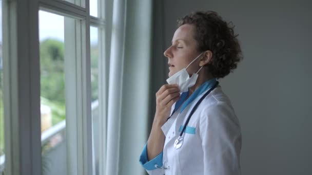 Pencere Kenarındaki Kadın Doktor Rahatça Maskesini Çıkarıyor Maskeli Cüppeli Kadın — Stok video
