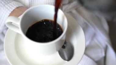 Sabah ayininin kapanışı, aromatik koyu kahve çay tabağının üzerine beyaz bardağa dökülüyor. Kahvenin kokusu odayı doldurur, neşelendirir. Bir damla kahve gerçek zevktir, ince bir aroma ve zengin bir tat ile işaretlenmiştir.