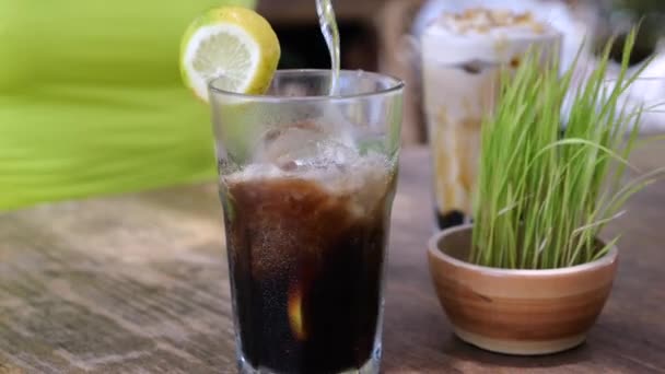 Verter Agua Soda Vaso Con Hielo Limón Mesa Café Aire — Vídeo de stock