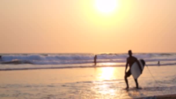 Sahilde Parlak Kırmızı Günbatımında Bulanık Sörfçü Silueti Dalgalar Boyunca Deniz — Stok video
