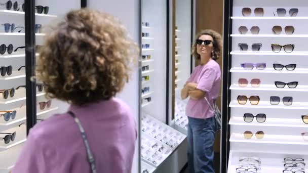 Στο Κατάστημα Οπτικών Γυναίκα Προσπαθεί Μοντέρνα Γυαλιά Ηλίου Μοντέλο Στον — Αρχείο Βίντεο