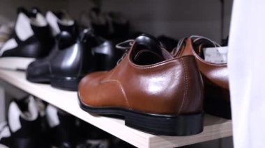 Mağazada farklı stil ve renkte geniş erkek çizmeleri var. Yakın plan: dükkandaki kahverengi erkek botları. Konsept: eşleşen erkek botları her zaman raflarda bulunabilir