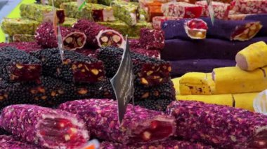 Market tezgahında renkli bereketli bir oryantal tatlı kilisesi. Farklı renklerde kalın kremalarla kaplı lezzetli fındıklardan yapılmış yakın plan tatlı. Doğa tatlısı doğal malzemelerden yapılır.