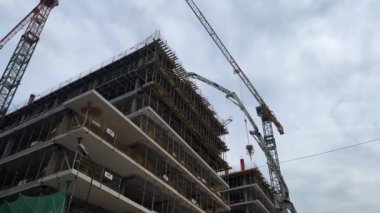 Varşova, Polonya - 01 Mayıs 2024 Metropolis 'te ev yapımı sırasında vinç hareketi. Gökdelen inşa eden güçlü turnalar. İnşaat vinçleri yakın planda olan müstakbel evin beton yapısı.