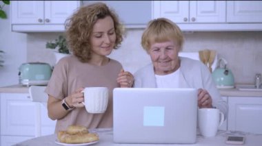 Büyükanne, dizüstü bilgisayarından yetişkin torunuyla konuşuyor. Modern teknolojiye bayılıyor. Büyük anne ve orta yaşlı torun yaşlılıkta dizüstü bilgisayar ilişkileri üzerine sohbet ediyorlar.