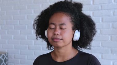 Kulaklık takan Asyalı kadın müzikten hoşlanıyor. Gözleri kapalı kadın kulaklıkla meditasyon yapıyor. Çekici bir kadın kendini kulaklığa sokuyor. Rahatlama ve sükunet sağolsun.
