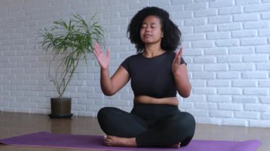 Güney Asyalı kadın evde meditasyon yapıyor. Sakin meditasyon iç dengeyi bulmamıza yardımcı olur. Stres atmak ve refahı artırmak için düzenli meditasyon. Antrenmanlara derin dalma.