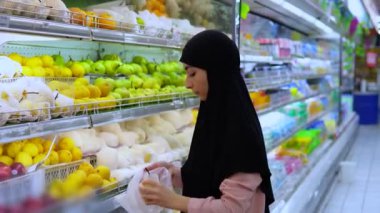 Müslüman ve Kafkasyalı kadınlar markette birlikte yiyecek seçerler. Mağazadaki çeşitlilik ürünleri farklı kültürlerden müşterileri çekiyor. Alışveriş yaparken mağaza buluşma yeri ve sosyalleşme yeri. 