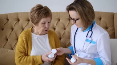 Kadın gerekli ilaçları ve talimatları doktordan alır. Doktor yaşlı hastalara ilaç kullanmaları konusunda tavsiyelerde bulunuyor. Yaşlılara bakıyorum. Tıbbi bakım, ihtiyarlara bakım.