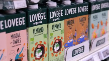 Varşova, Polonya - 01 Mayıs 2024: Ürün çeşitliliği ve canlı ambalajları gösteren renkli organik badem ve yulaf sütü kutuları tüketici seçimi için süpermarket rafında düzgünce konumlandırılırken