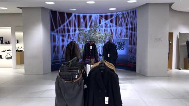 Varşova, Polonya - 01 Mayıs 2024: Hız trenleri ve soyut modeller de dahil olmak üzere çeşitli tasarımları gösteren animasyonlu grafikler, modern bir perakende ortamda bir giyim sergisini aydınlatıyor