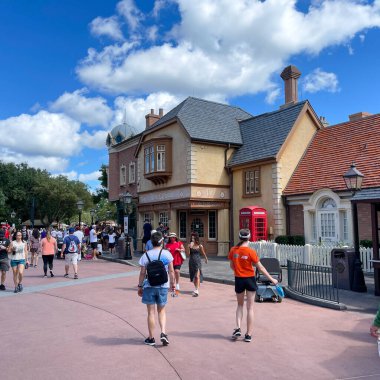 Orlando, FL USA- 9 Ekim 2021: Orlando, Florida 'daki Walt Disney World' de Birleşik Kindgom bölgesinde yürüyen insanlar.