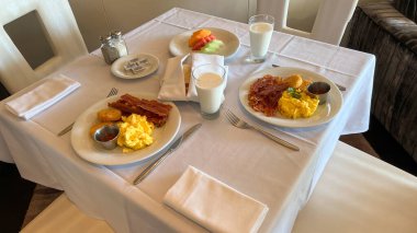 Port Canaveral, FL USA - 13 Ocak 2022: Bir yolcu gemisinde bir restoranda çırpılmış yumurta, pastırma ve süt kahvaltısı.
