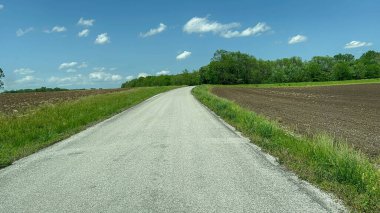 Güneşli bir bahar gününde, Evansville yakınlarındaki kırsal bölgede, yolun her iki tarafında çiftlikleri olan IL 'de araba sürüyorum..