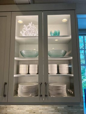 Kiawah Island, SC USA - February 26, 2023:  Organized glass cabinets in the kitchen of a luxury vacation rental home on Kiawah Island in South Carolina. clipart