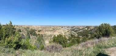 Güneşli bir günde, Kuzey Dakota 'daki Theodore Roosevelt Ulusal Parkı' ndaki Oxbow Overlook 'daki Çorak Topraklar tepeleri ve dağlar.
