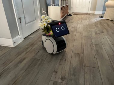 Orlando, FL USA - 9 Aralık 2022: Bir Amazon Astro robotu bir evi Orlando, Florida ABD 'de bir ev güvenlik aygıtı olarak izliyor.