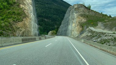 Kanada 'da bulutlu bir bahar gününde Yoho, Kootenay, Banff ve Jasper Ulusal Parkı yakınlarındaki Trans Canada Otoyolu' nu sürerken manzara.