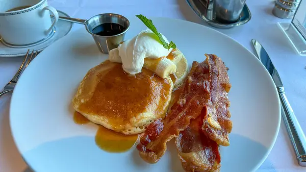 Port Canaveral, FL USA - January 15, 2022:  Buttermilk pancakes, bacon and coffee breakfast at a restaurant on a cruise ship.